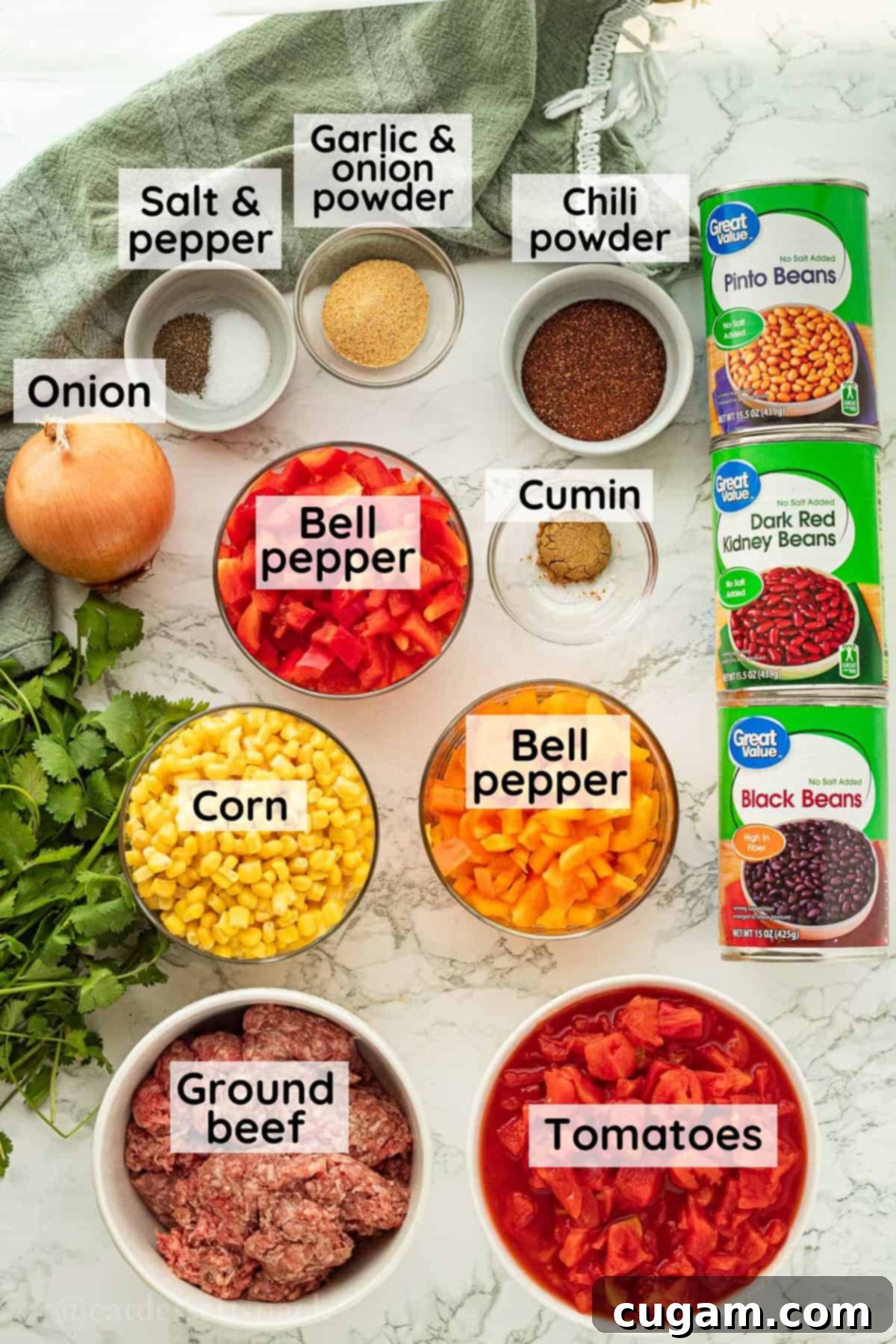 Assortment of fresh, labeled ingredients for healthy taco soup, arranged in glass bowls on a sleek marble countertop, ready for preparation.