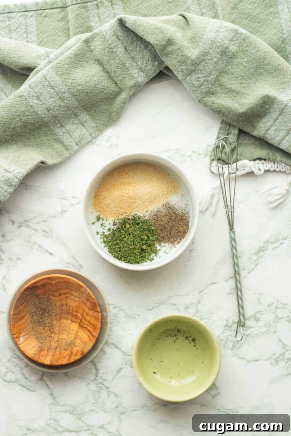 A small white bowl filled with a vibrant mix of dried spices: salt, pepper, parsley, garlic powder, and onion powder.
