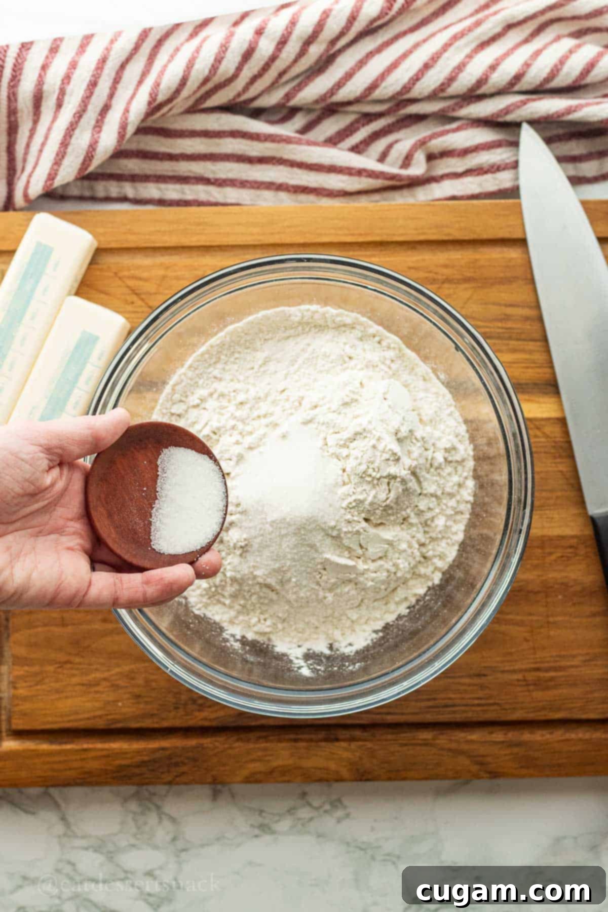 Pouring sugar and salt into flour.