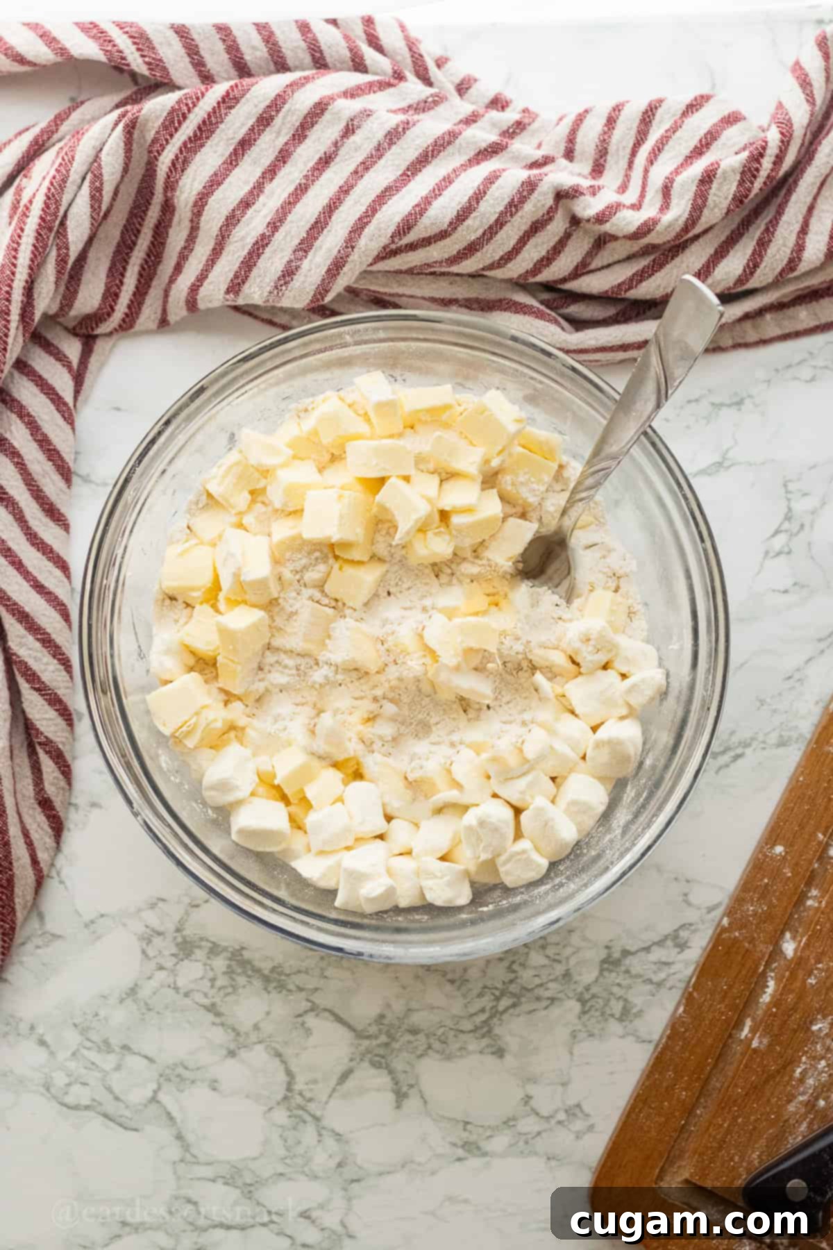Butter and cream cheese in glass bowl with flour.