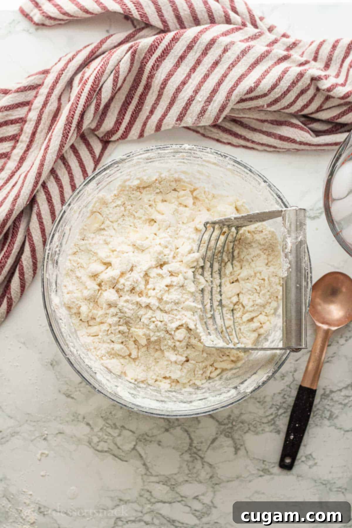 Cutting butter and cream cheese into flour with pastry cutter.