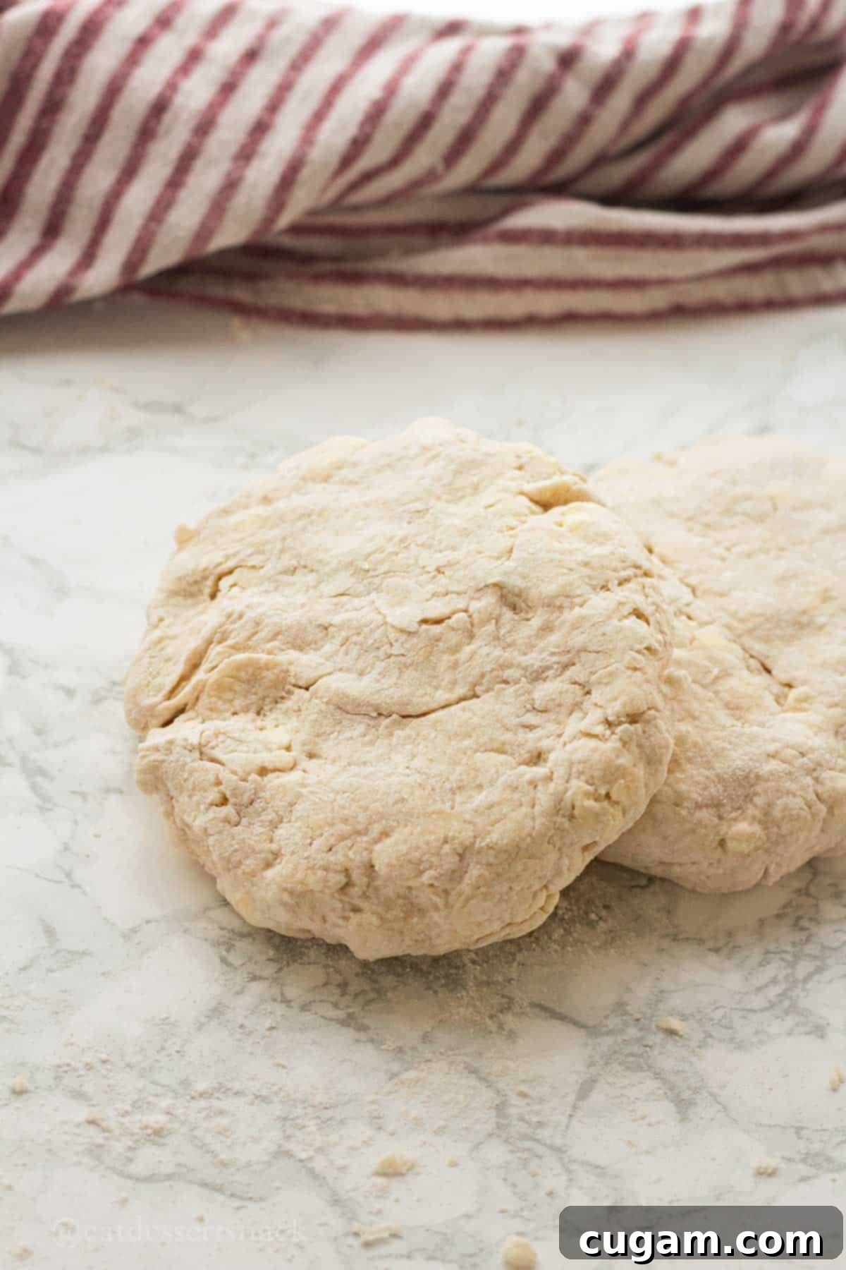 Cream Cheese pie dough disc on marble countertop.