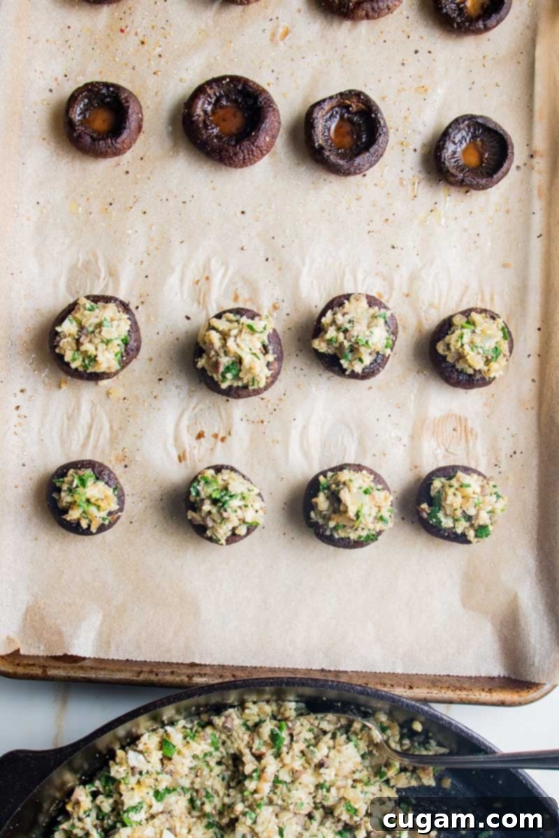 Par-baked mushrooms being stuffed with gluten-free filling.