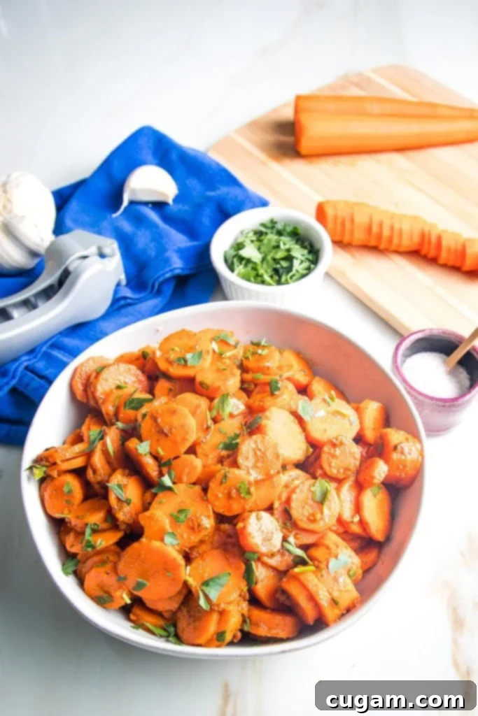 Close up of spiced sliced carrots with fresh parsley and minced garlic, highlighting the vibrant colors and textures.