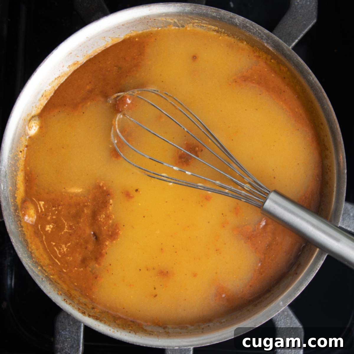 Veggie stock is whisked into mixture to thin out the enchilada sauce. 