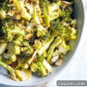 close up of a bowl of roasted broccoli with sliced almonds