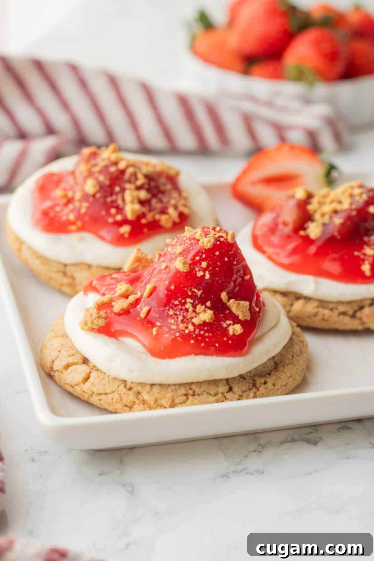 Baked strawberry cheesecake cookie on white plate.