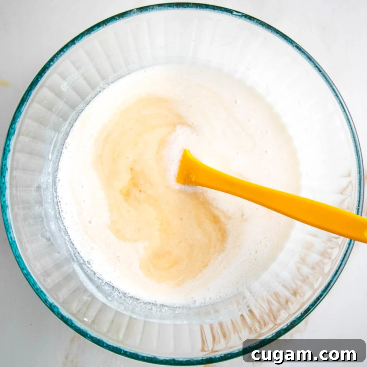 Mixing together almond milk, applesauce, apple cider vinegar, and maple syrup in a bowl.