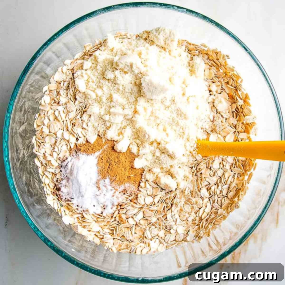 Sprinkling dry ingredients like oats, almond flour, arrowroot powder, baking powder, and spices into the wet mixture.