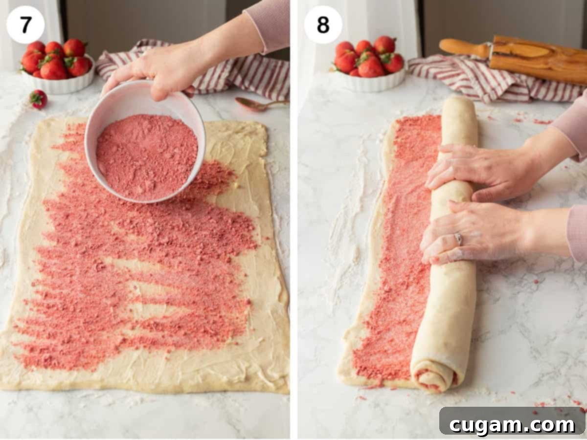 Strawberry sugar filling over buttered dough and hands rolling dough into long roll.