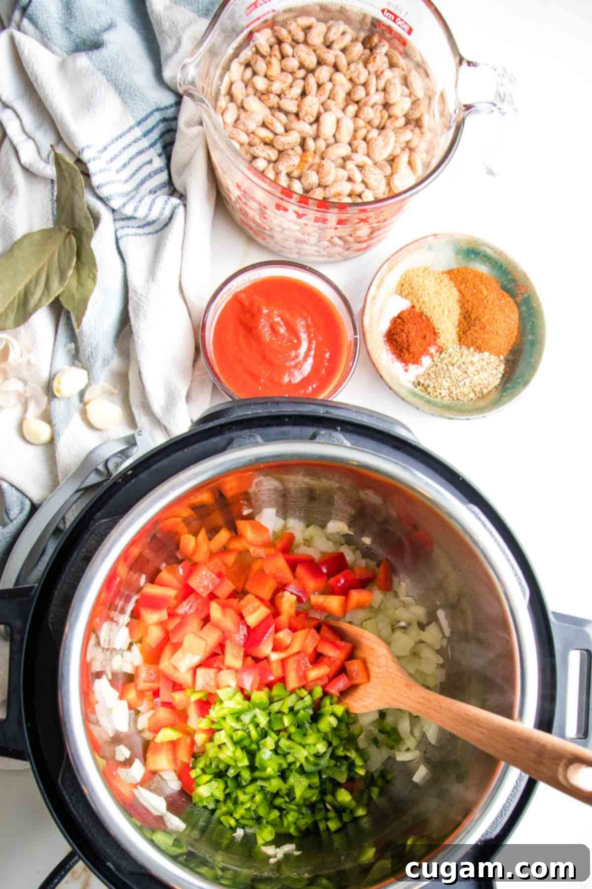Soaked dried pinto beans, tomato sauce, spices and veggies sauteeing in the instant pot.