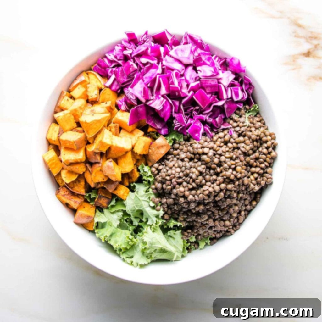 A vibrant pile of freshly chopped purple cabbage, adding a beautiful pop of color and essential crunch to the salad.