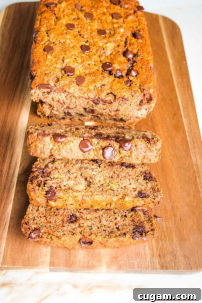 Super moist and healthy chocolate chip zucchini bread slices on a wood grained cutting board.