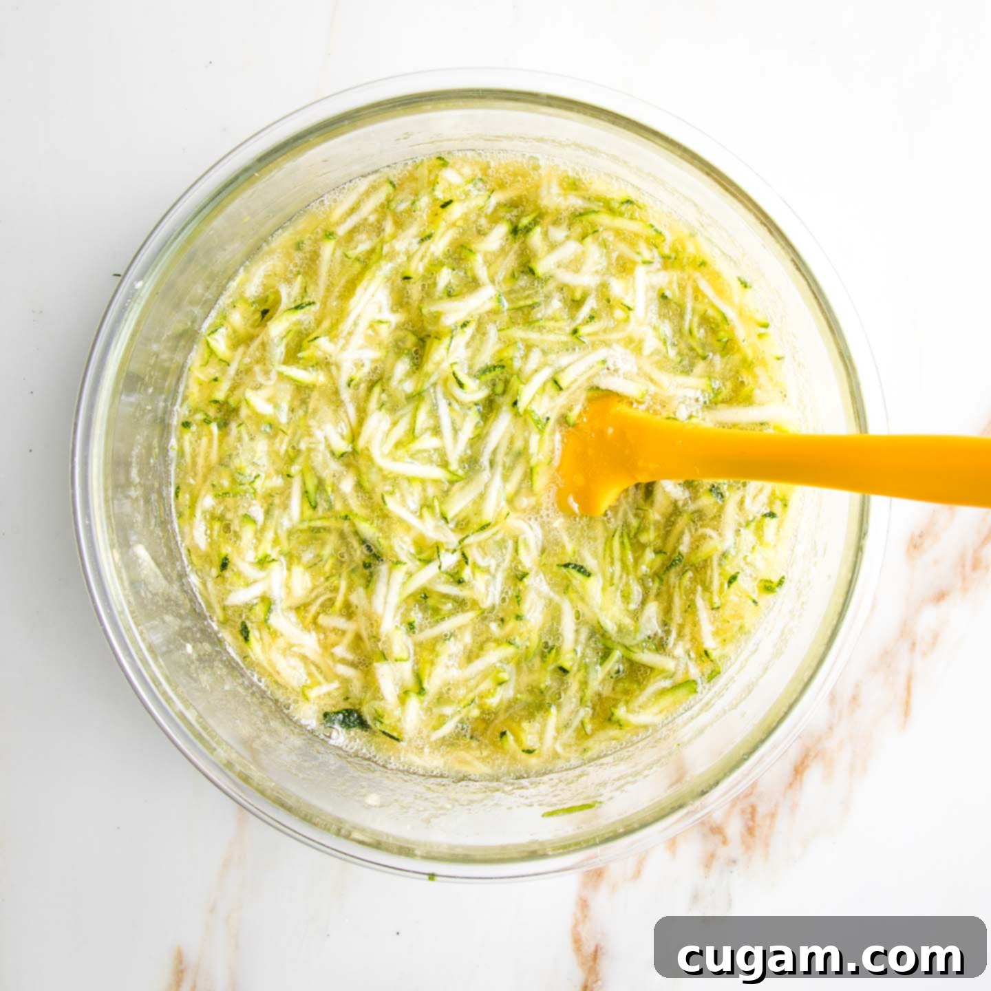 Shredded zucchini mixed with applesauce and honey.