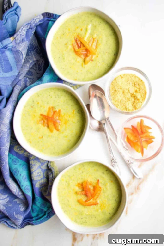 Zucchini Soup Delight 2 Creamy green soup in bowls with red pepper garnish.