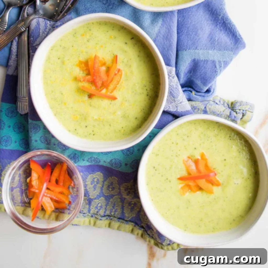 Zucchini Soup Delight 12 Two bowls of creamy green soup, garnished with julienned red pepper slices.