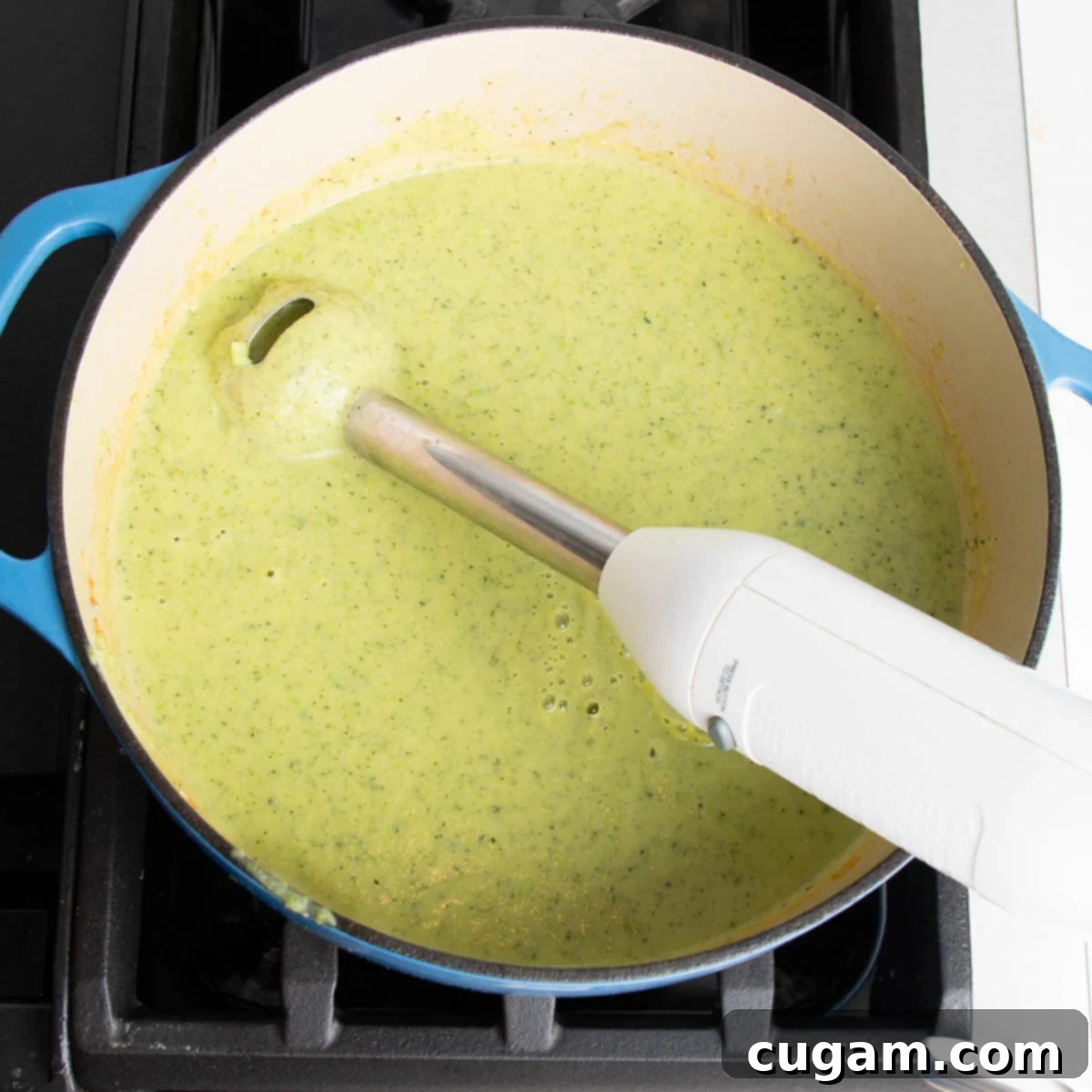 Easy Creamy Zucchini Soup 10 Immersion blender in a dutch oven, pureeing light green soup.