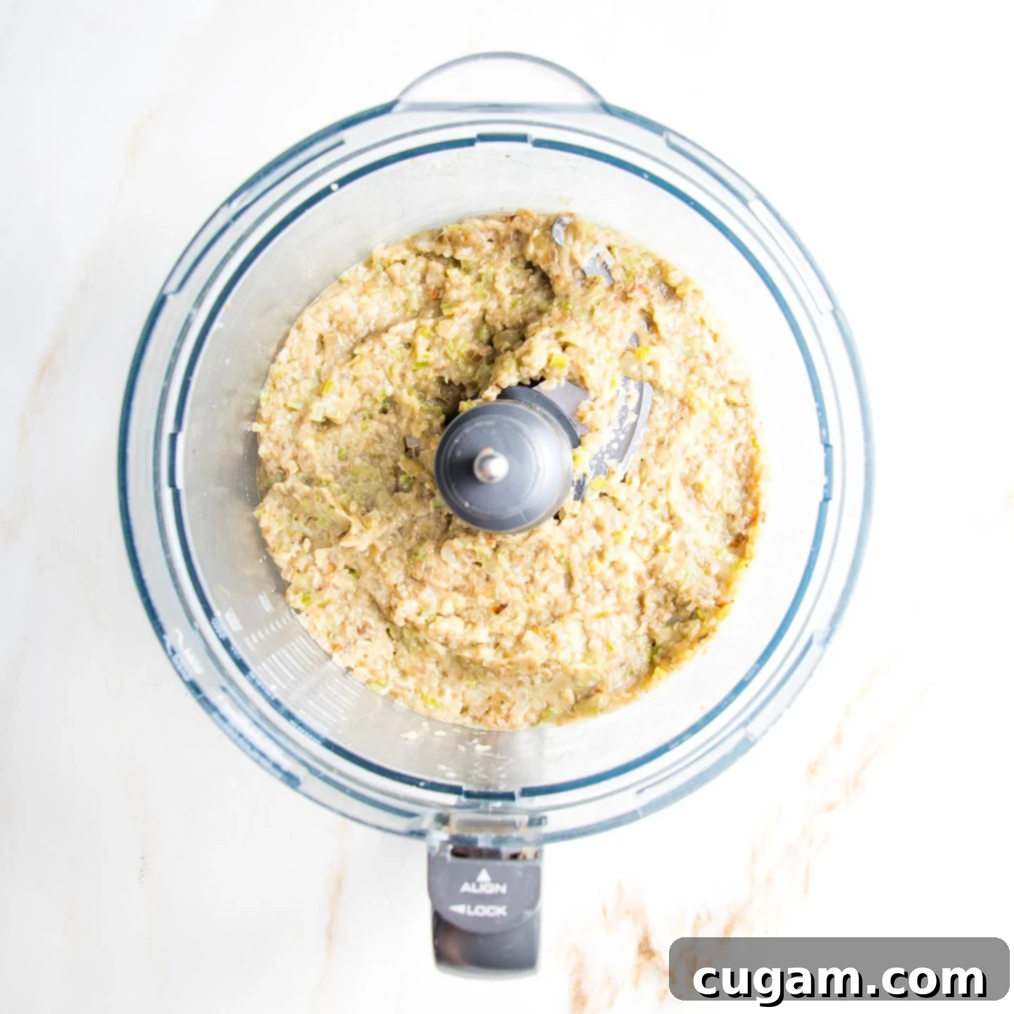 Chunky eggplant dip in the bowl of a food processor.