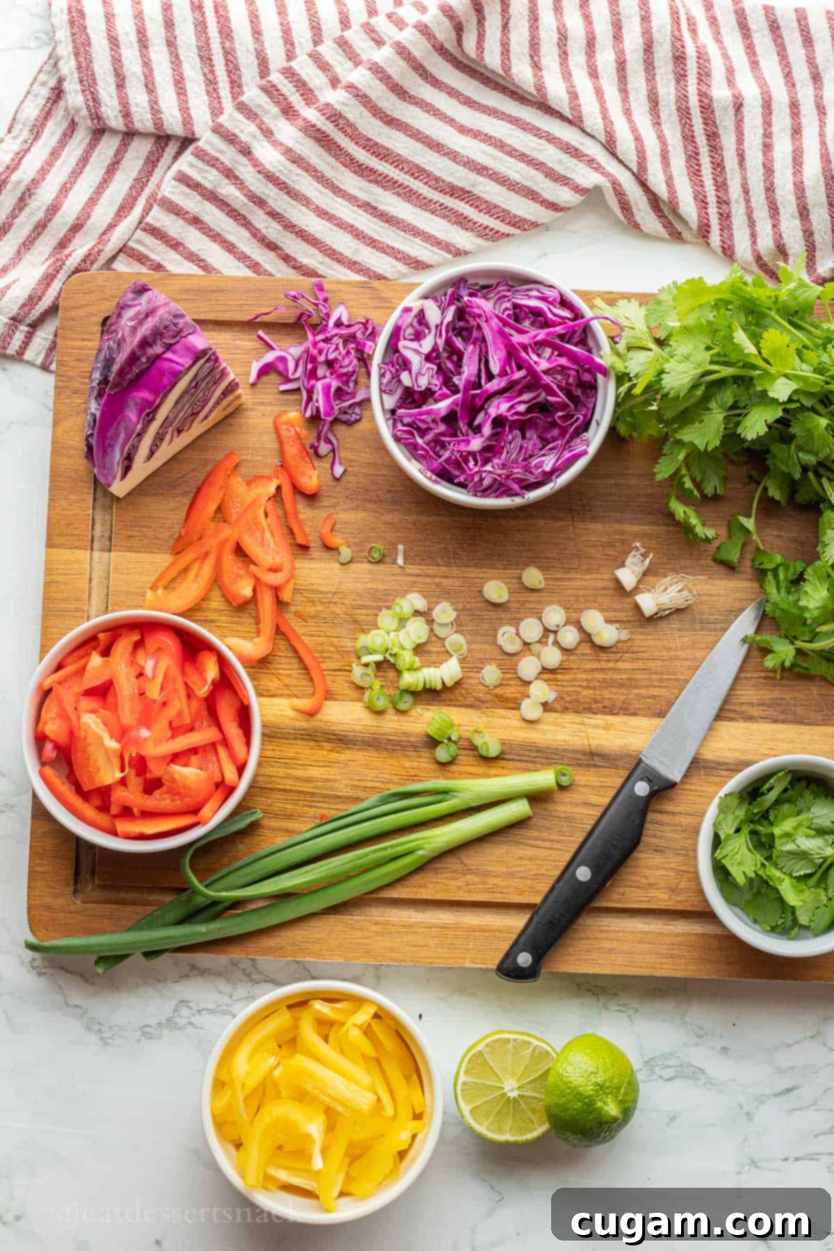 Chopped vegetables with knife on wood cutting board.