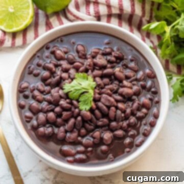 Cooked black beans with cilantro in white bowl.