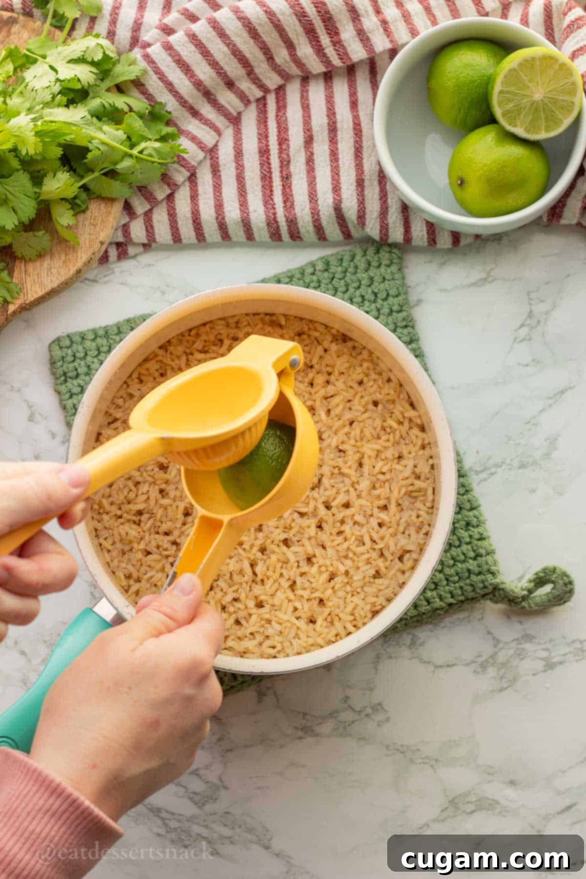 Squeezing lime juice into pot of cooked rice.