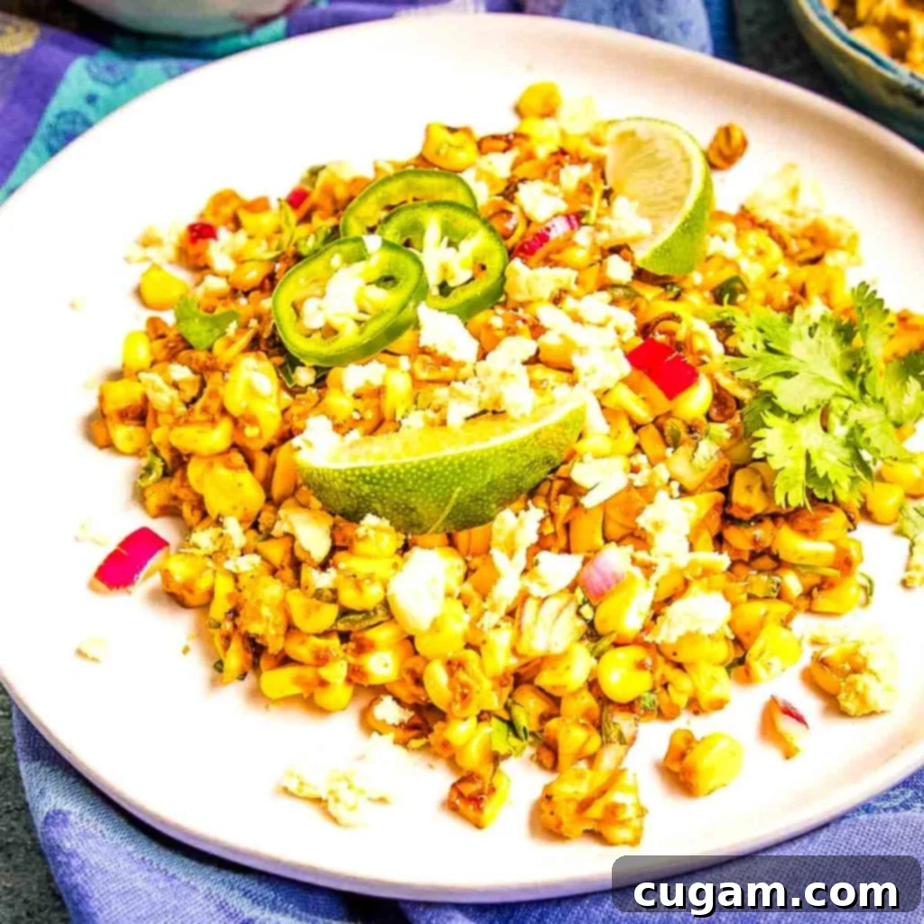 Delicious Vegan Mexican Street Corn 3 Corn salad with pops of color, lime wedges, jalapeno slices and fresh herbs, ready to be served.