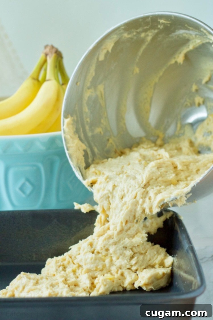 Banana Coffee Cake batter pouring into dark pan. 
