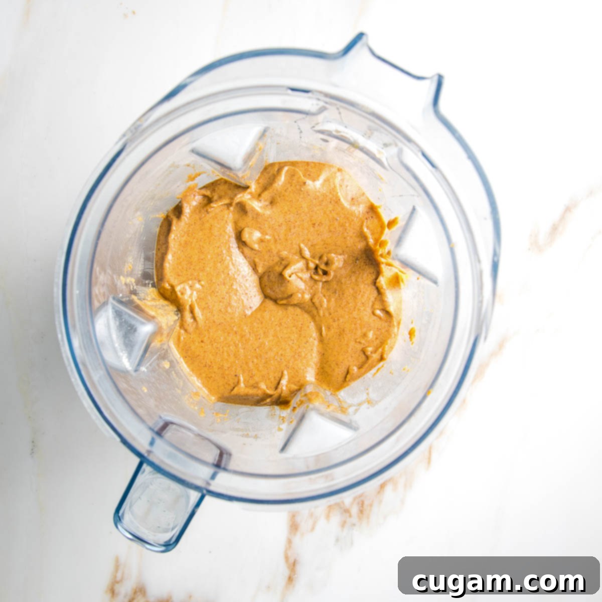 Blender pitcher with pumpkin muffin batter.