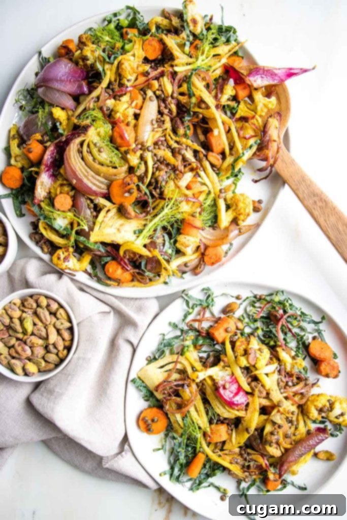 Beautifully arranged roasted vegetables including carrots, fennel, onions, and cauliflower, mixed with dark beluga lentils, green pistachios, and golden raisins, served on elegant white plates.