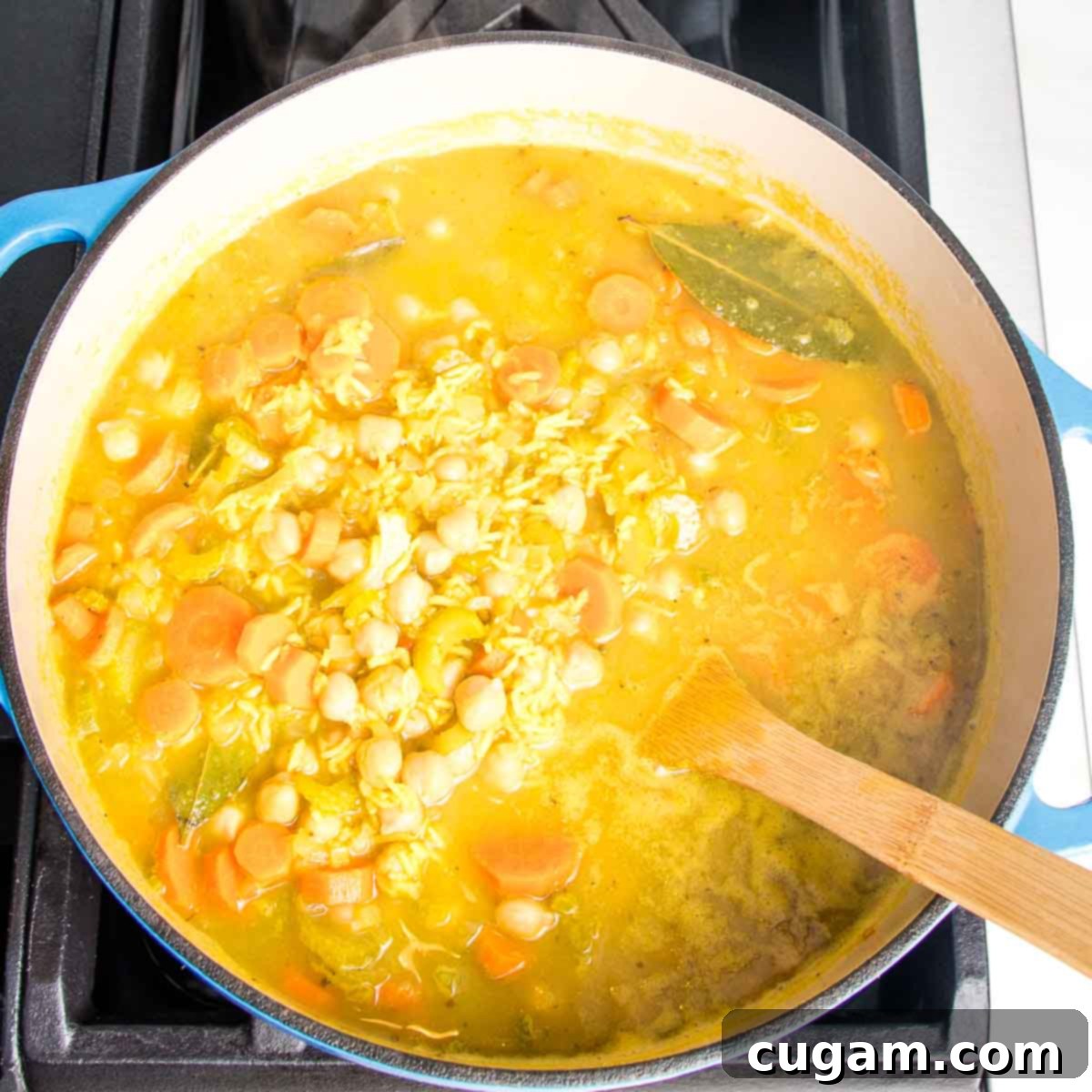Nourishing Vegan Lemon Chickpea Rice Soup 11 Dutch oven with a rich, yellow chickpea soup, ready for the final touches.