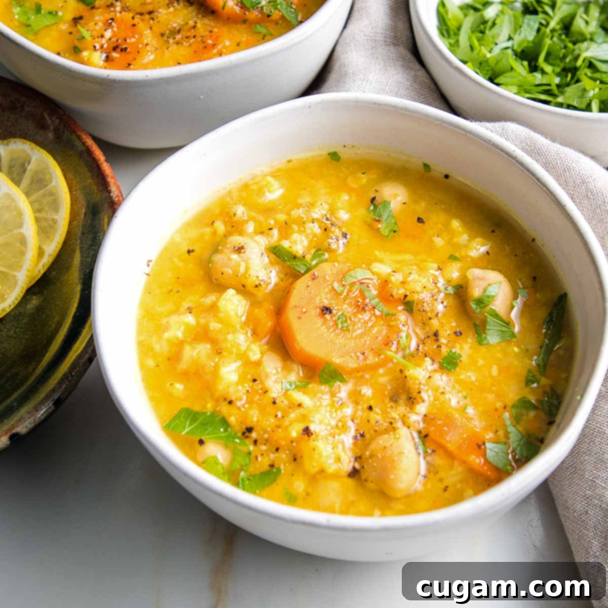 Nourishing Vegan Lemon Chickpea Rice Soup 3 White bowl filled with chickpea rice soup, ready to be enjoyed.