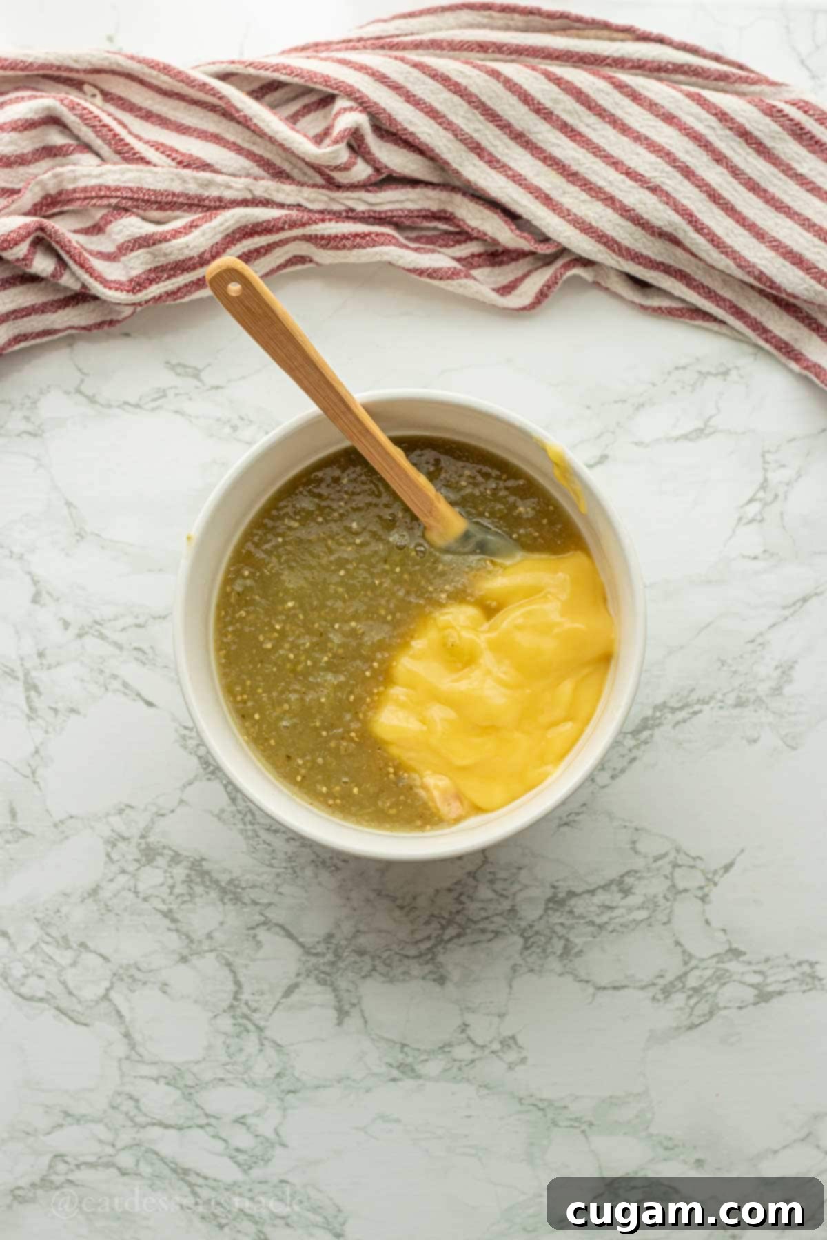 Salsa verde and cream of chicken soup combined in a small bowl, forming the enchilada sauce.