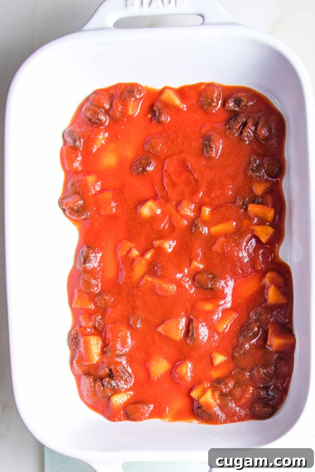 Hearty Vegan Cabbage Bundles 15 Sweet and sour sauce spread onto the bottom of a baking dish.