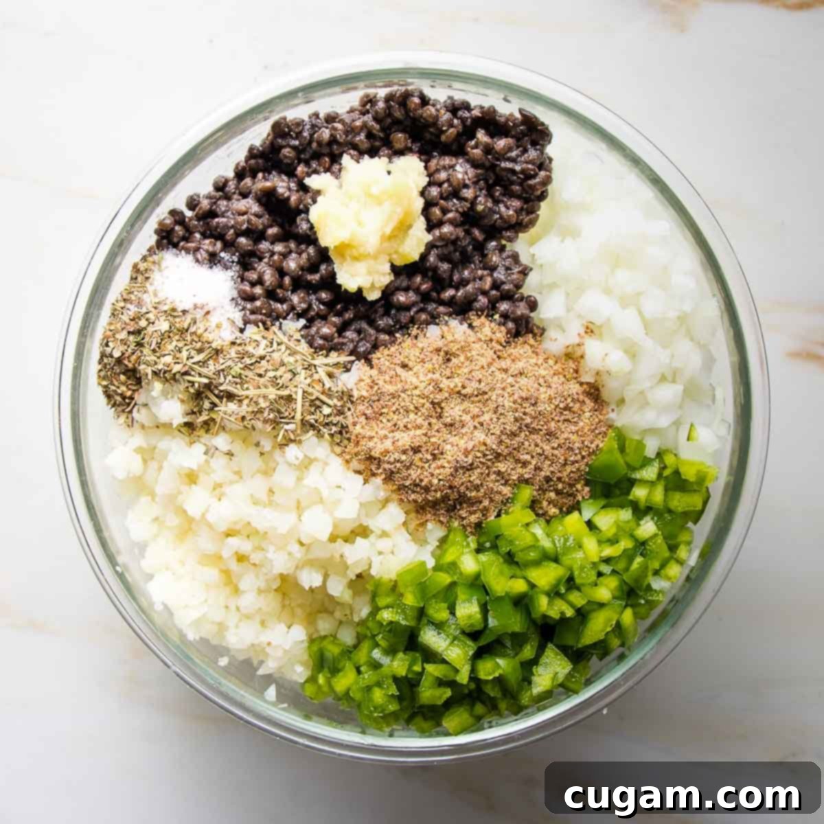 Hearty Vegan Cabbage Bundles 8 Bowl with sections of diced onions, green peppers, cauliflower rice, ground flax, spices, lentils and pressed garlic.