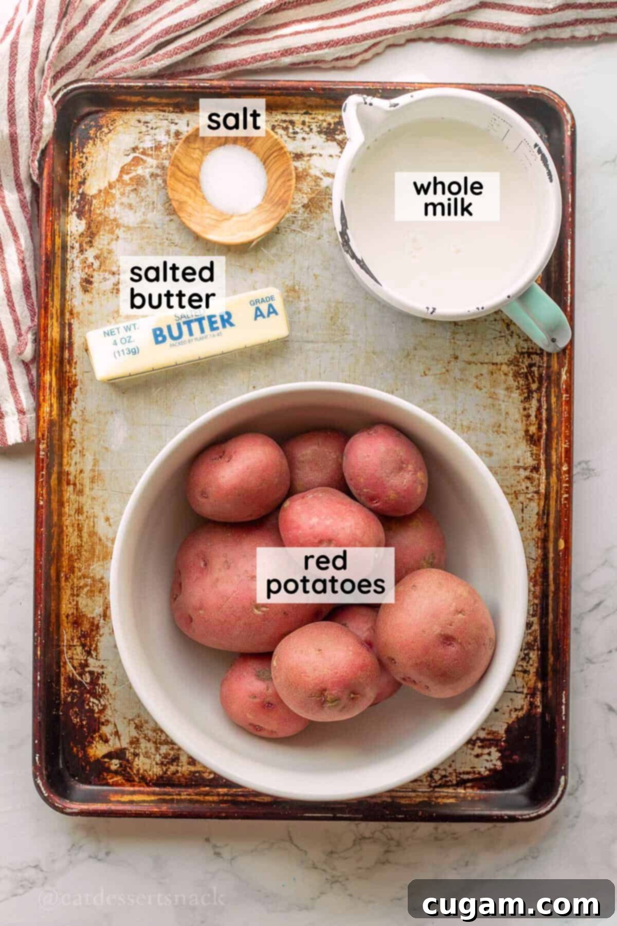 Labeled ingredients for red skin mashed potatoes in bowls on metal baking sheet.