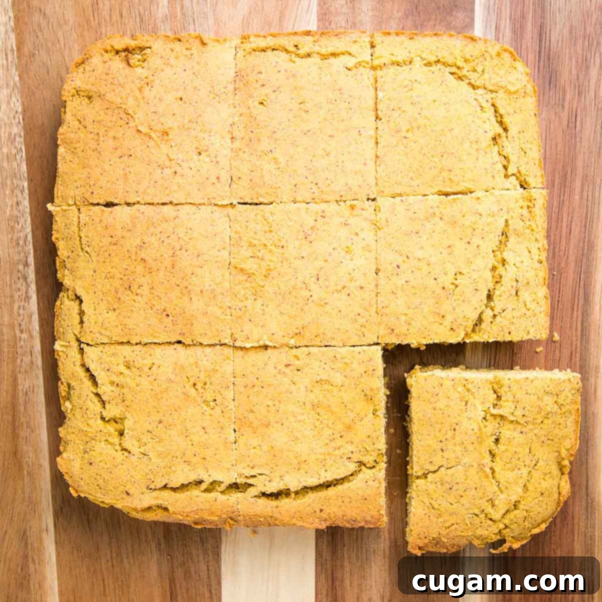 Gluten-Free Vegan Double Corn Cornbread 13 A freshly baked square cornbread, removed from its pan, is neatly cut into large, uniform squares on a cutting board, ready for serving.