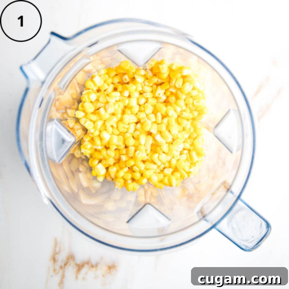 Gluten-Free Vegan Double Corn Cornbread 4 Defrosted frozen corn kernels, water, and olive oil are placed inside the pitcher of a blender, ready for blending.