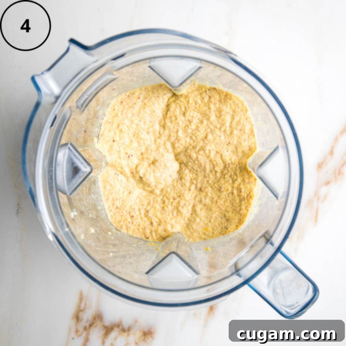 Gluten-Free Vegan Double Corn Cornbread 7 All the wet ingredients for the cornbread, including the corn mixture, flaxseed, and maple syrup, are thoroughly blended together in the blender pitcher, forming a uniform, pale yellow batter.
