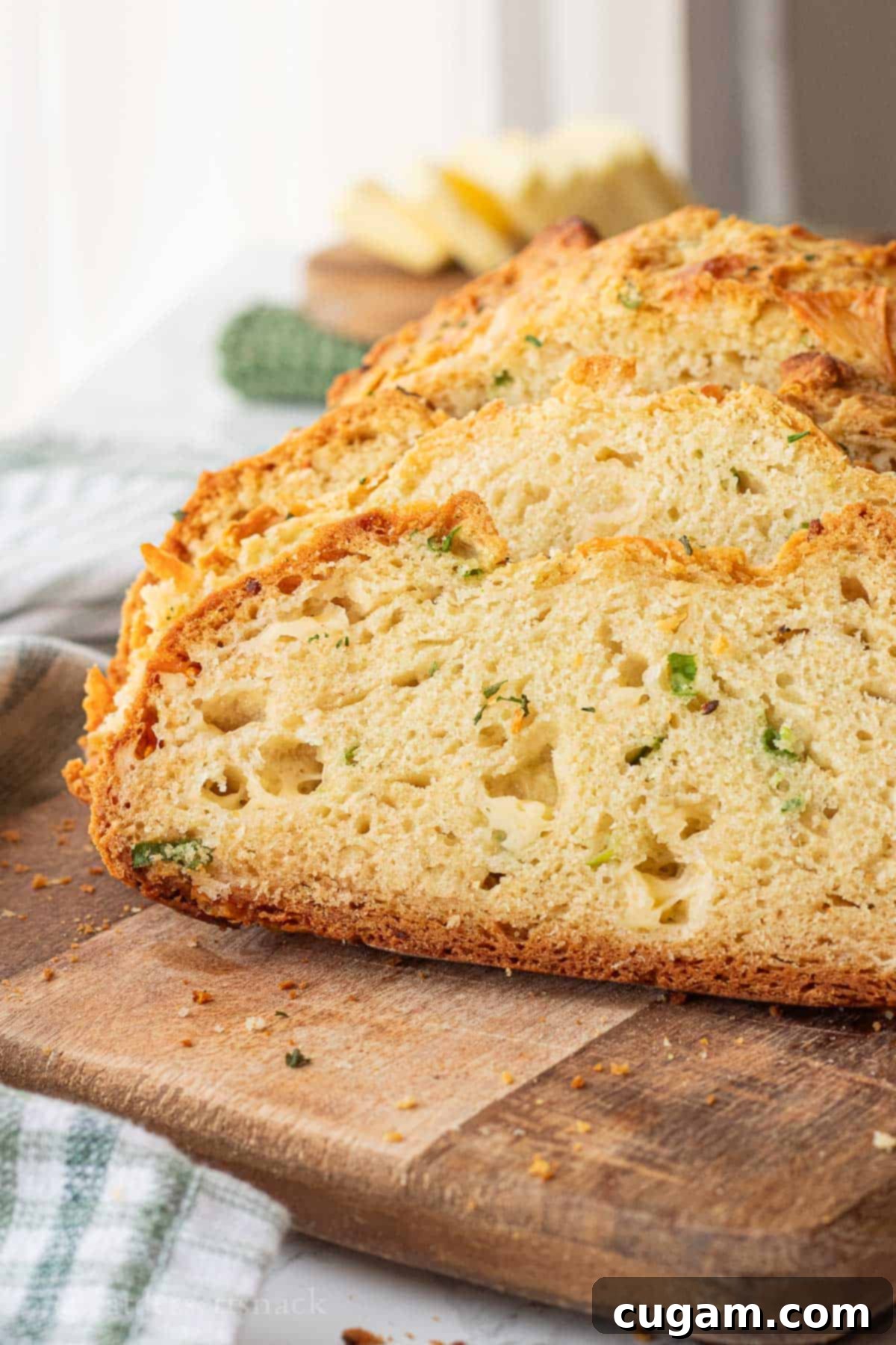 Sliced cheddar soda bread on wood cutting board.