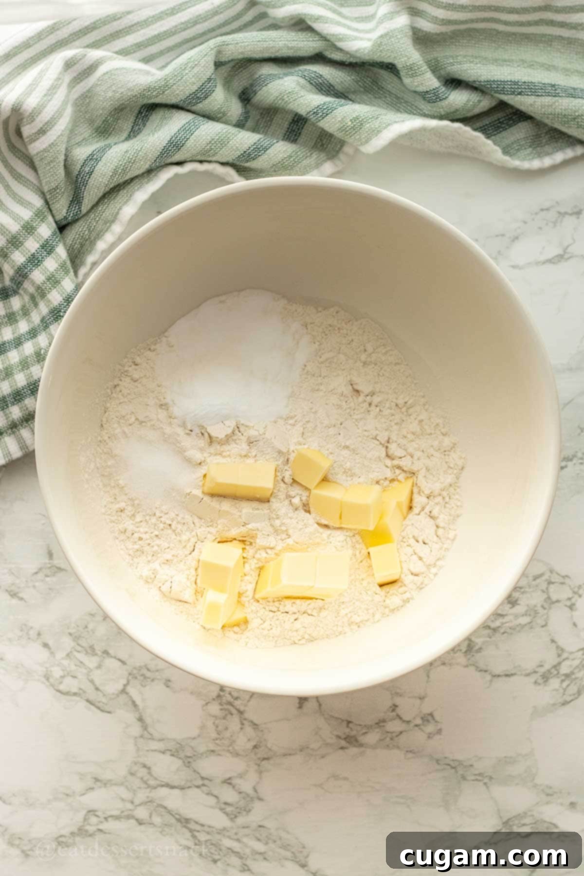 Butter in flour mixture in white bowl.