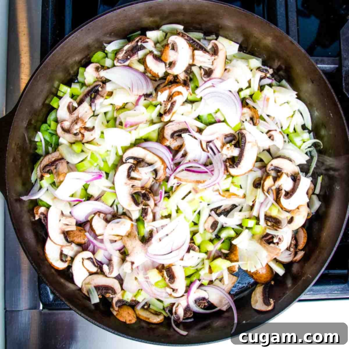 Sautéed vegetables including mushrooms, onions, celery, and fennel caramelizing in a cast iron pan, showing a rich golden color.