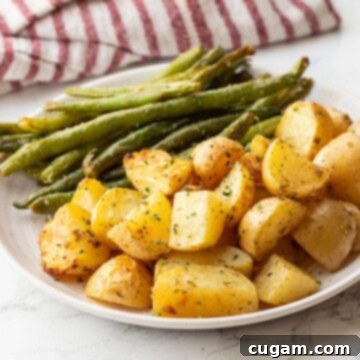 Baked green beans and potatoes on white plate.