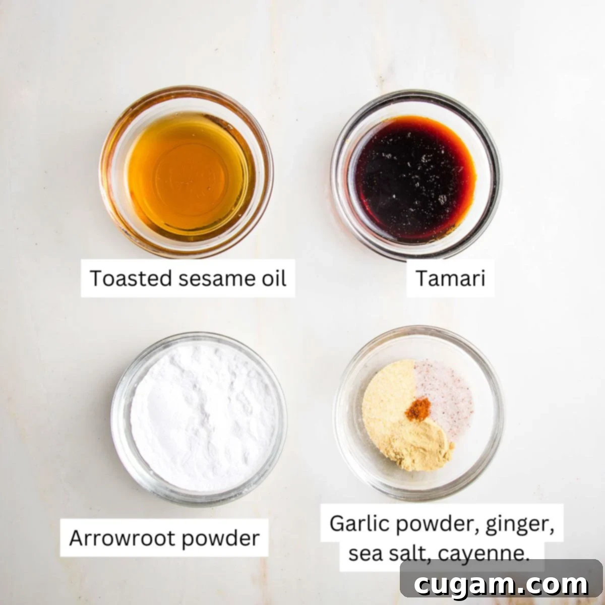 Labeled small bowls with sesame oil, tamari, arrowroot and spices.