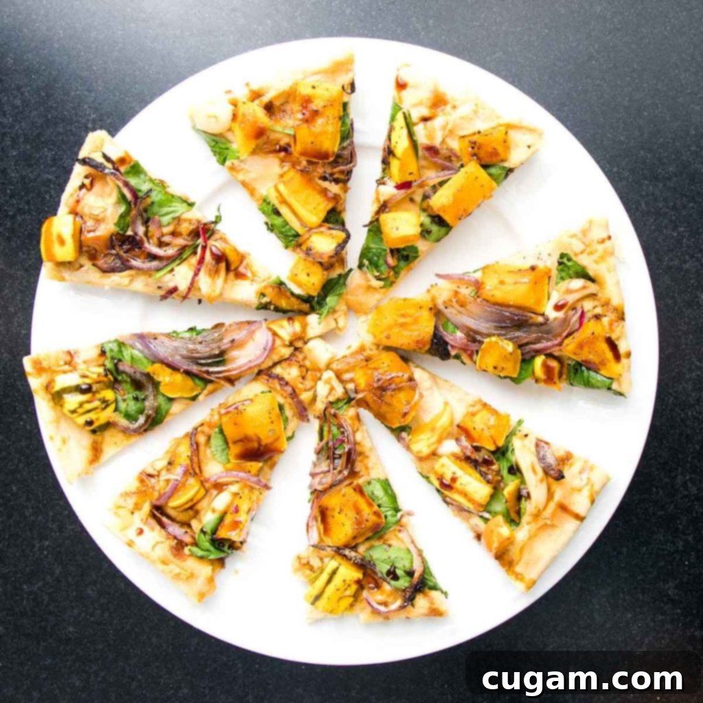 Delicious slices of vegan flatbread, generously topped with creamy hummus and roasted vegetables, elegantly finished with a sweet date syrup drizzle.