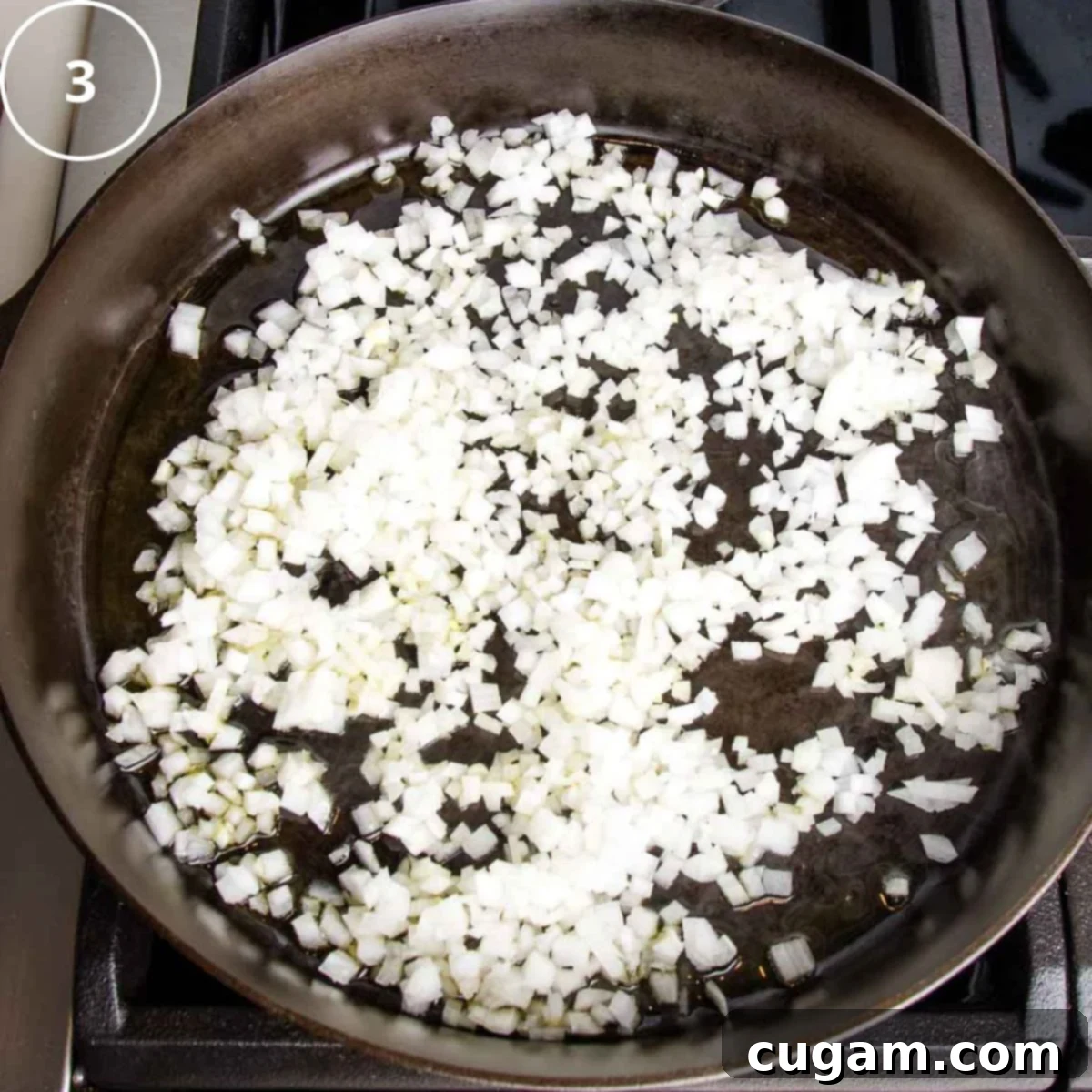 A cast iron skillet on a stovetop with diced onions sautéing in a small amount of vegetable broth until softened.
