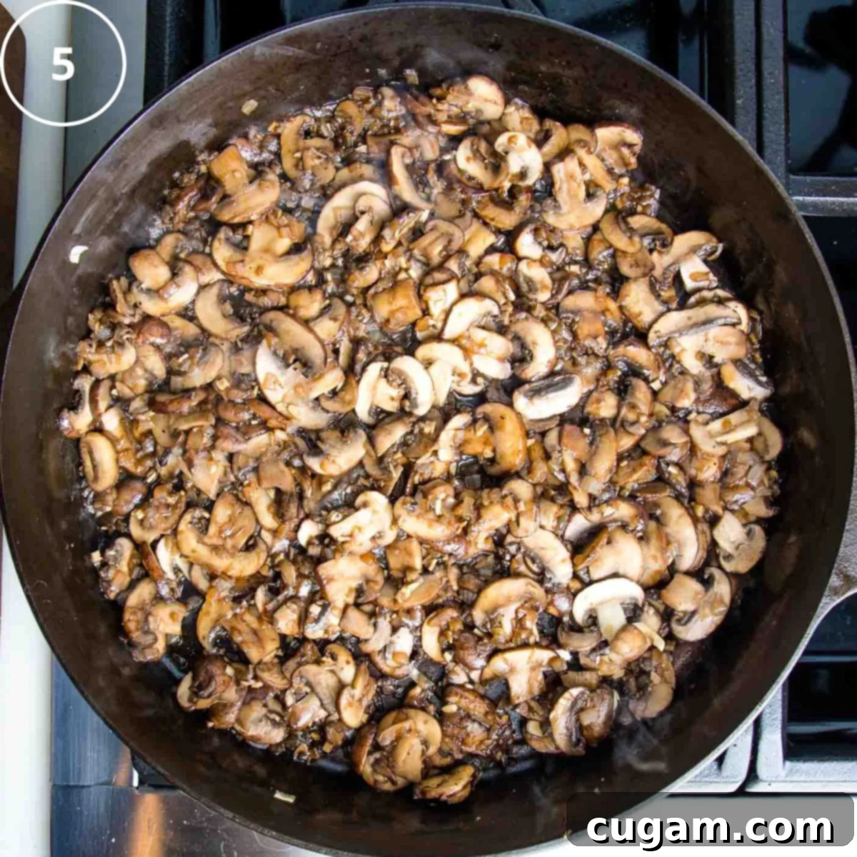Balsamic vinegar being poured into a cast iron skillet with cooked mushrooms and onions, initiating the deglazing process.