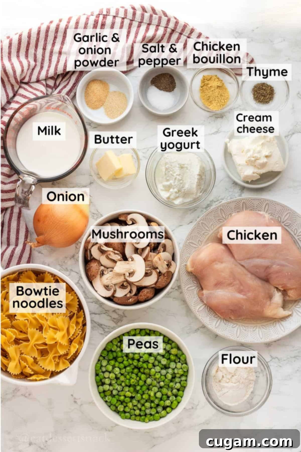 All the fresh ingredients for Chicken Mushroom Stroganoff with Greek Yogurt, arranged in glass bowls on a marble countertop.