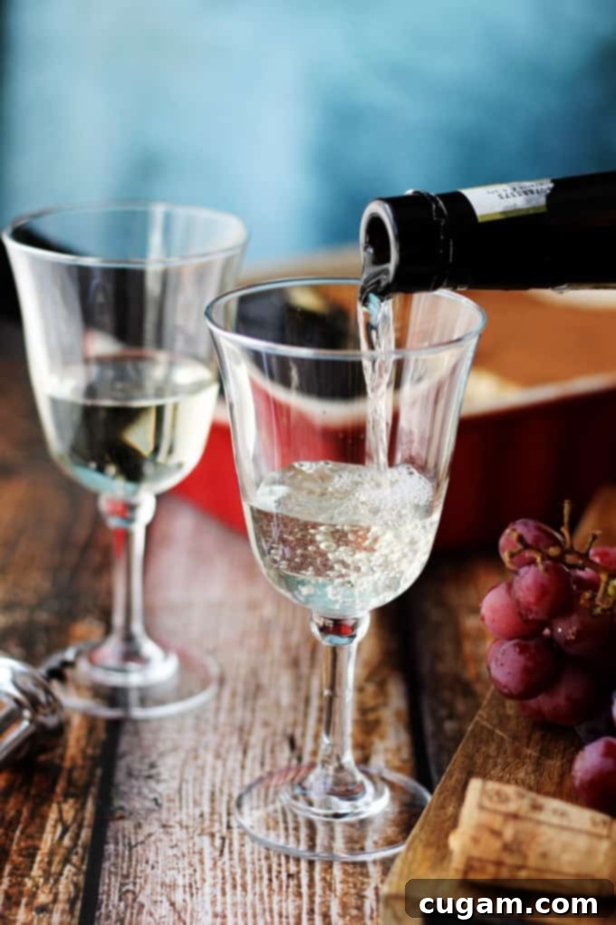 Pouring Italian Dessert Wine Moscato D'Asti into a wine glass, showcasing its golden hue and effervescence.