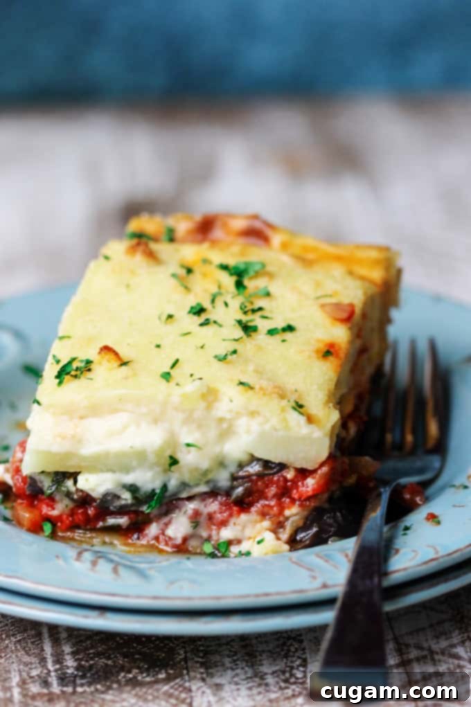 A piece of Greek vegetarian moussaka on a blue plate with fork