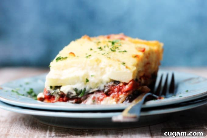 Horizontal shot of a vegetarian moussaka on a blue plate with fork
